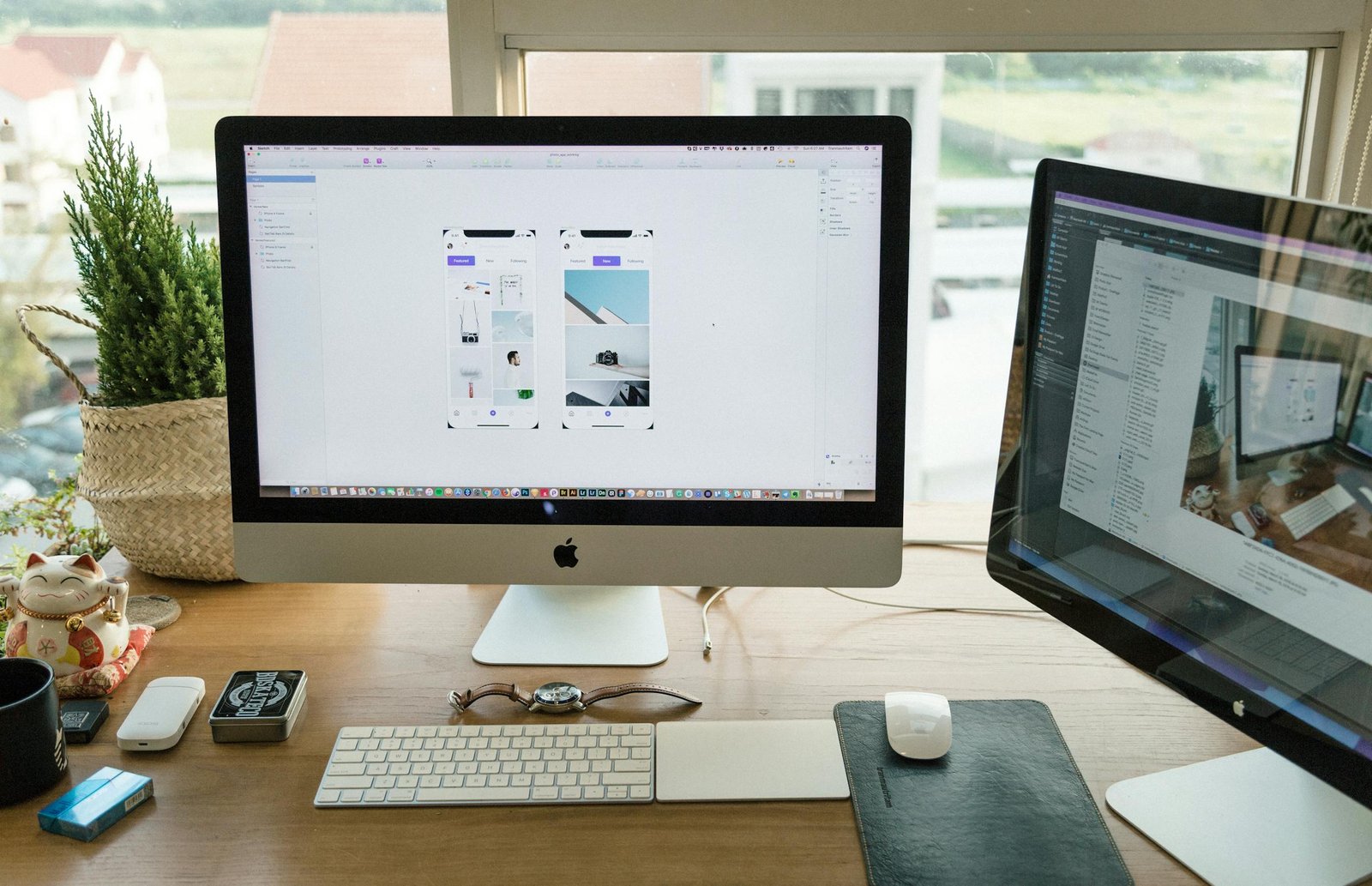 A well-organized modern office setup featuring Apple iMac and multiple monitors in a bright workspace.